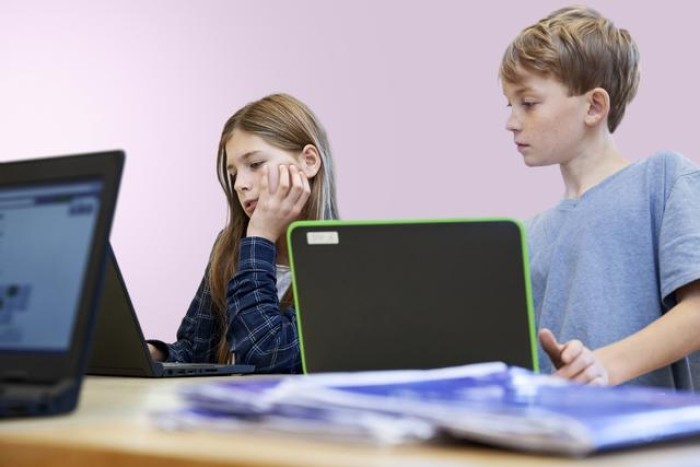 Two children using laptops