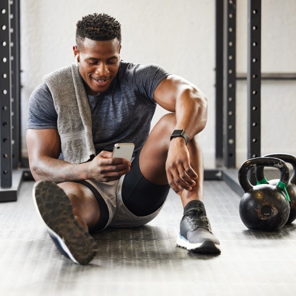Man in gym checks his mobile phone