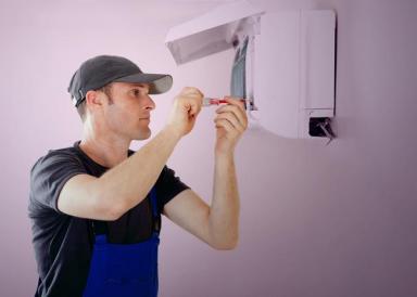 A man servicing an air conditioning unit
