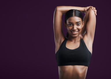 Lady stretching her triceps and smiling