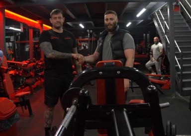 Two men shaking hands in a gym