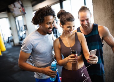 Group of friends at the gym looking at a mobile phone