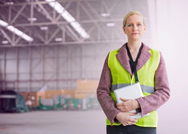 Lady in high-vis vest in an empty warehouse