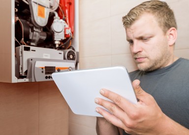 Boiler engineer consults his tablet