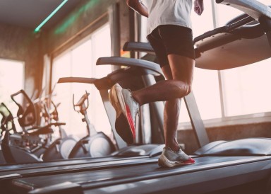 A man running on a treadmill in a gym