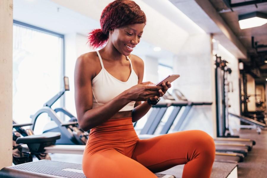 A lady reading an SMS message at the gym