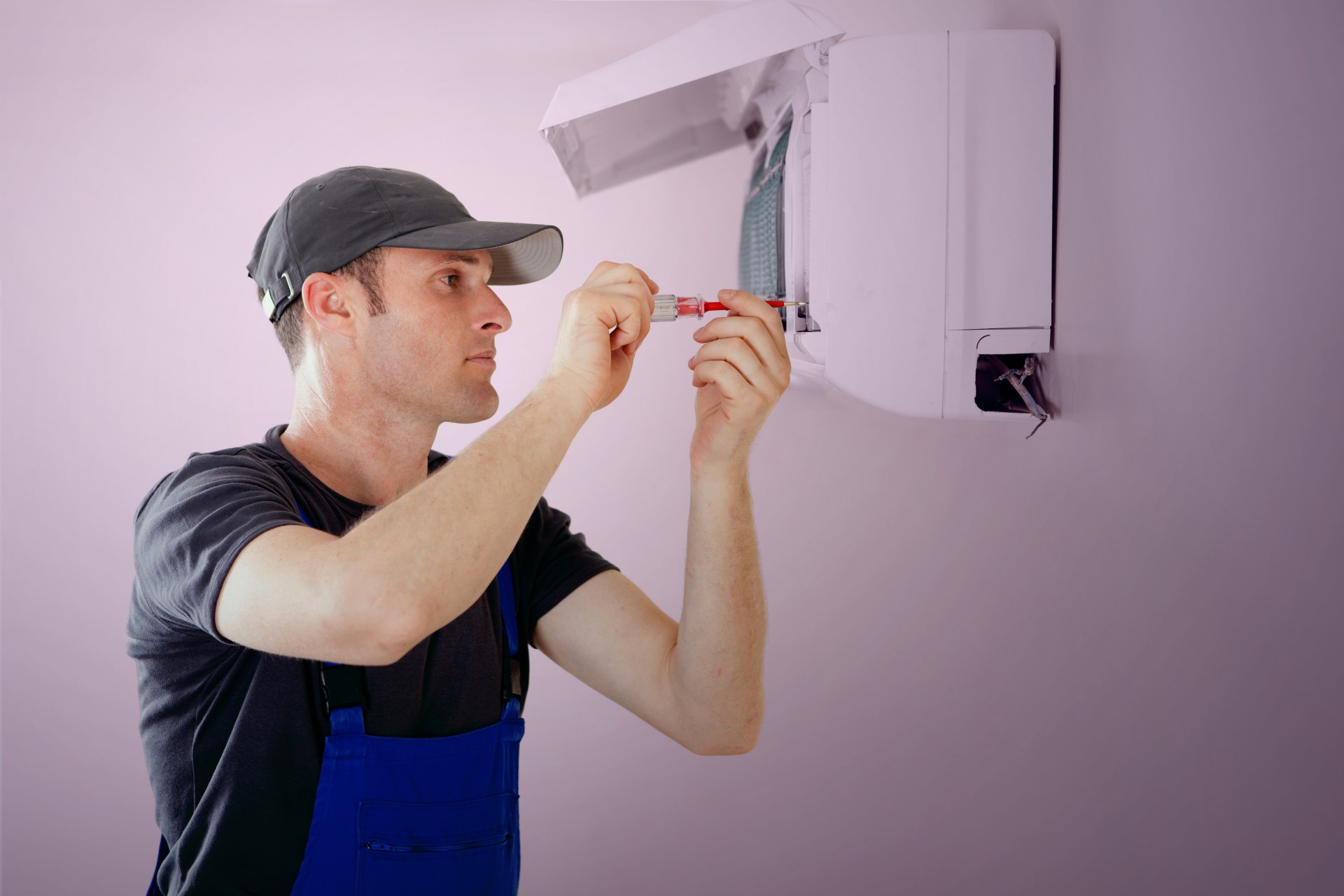 A man doing repair on a air condition